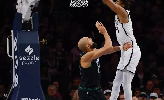 Brooklyn Nets center Nic Claxton, right, finishes an alley-oop over Minnesota Timberwolves center Rudy Gobert, left, during the first half of an NBA basketball game, Saturday, Dec. 27, 2025, in Minneapolis. (AP Photo/Bailey Hillesheim)