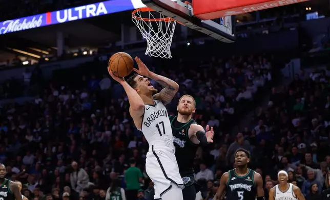Brooklyn Nets forward Michael Porter Jr. (17) goes up to shoot while Minnesota Timberwolves guard Donte Divincenzo, center right, defends during the second half of an NBA basketball game, Saturday, Dec. 27, 2025, in Minneapolis. (AP Photo/Bailey Hillesheim)