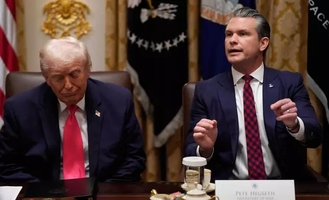 Defense Secretary Pete Hegseth speaks as President Donald Trump looks on, during a Cabinet meeting at the White House, Tuesday, Dec. 2, 2025, in Washington. (AP Photo/Julia Demaree Nikhinson)