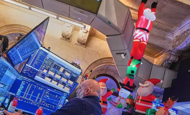 Trader Vincent Vincent Napolitano, surrounded by holiday decorations, works on the floor of the New York Stock Exchange, Thursday, Dec. 11, 2025. (AP Photo/Richard Drew)
