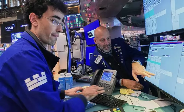 Specialists Alex Weitzman, left, and Meric Greenbaum work on the floor of the New York Stock Exchange, Thursday, Dec. 11, 2025. (AP Photo/Richard Drew)