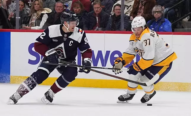 Colorado Avalanche left wing Gabriel Landeskog, left, loses control of the puck as Nashville Predators defenseman Nick Blankenburg covers in the first period of an NHL hockey game, Saturday, Dec. 13, 2025, in Denver. (AP Photo/David Zalubowski)