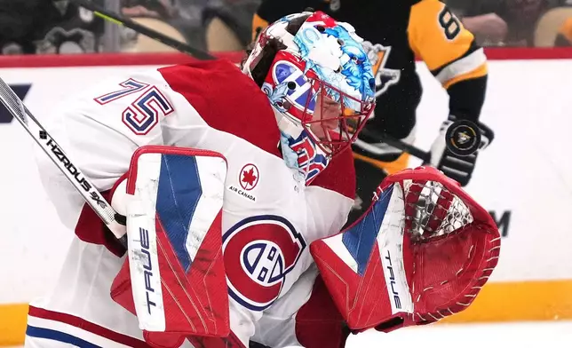 Montréal Canadiens goaltender Jakub Dobes takes a shot off his mask during the second period of an NHL hockey game against the Pittsburgh Penguins in Pittsburgh, Sunday, Dec. 21, 2025. (AP Photo/Gene J. Puskar)