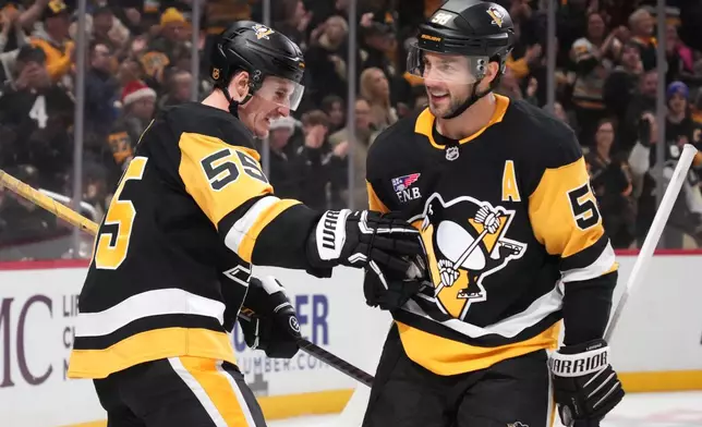Pittsburgh Penguins' Noel Acciari (55) celebrates after his goal with teammate Kris Letang, right, during the second period of an NHL hockey game against the Montréal Canadiens in Pittsburgh, Sunday, Dec. 21, 2025. (AP Photo/Gene J. Puskar)
