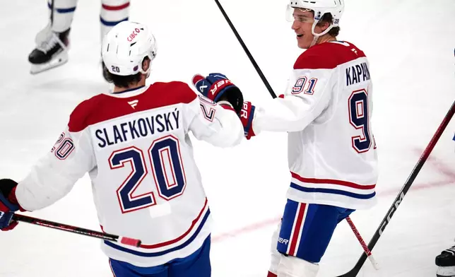 Montréal Canadiens' Oliver Kapanen, right, celebrates with Juraj Slafkovský (20) after scoring during the first period of an NHL hockey game against the Pittsburgh Penguins in Pittsburgh, Sunday, Dec. 21, 2025. (AP Photo/Gene J. Puskar)