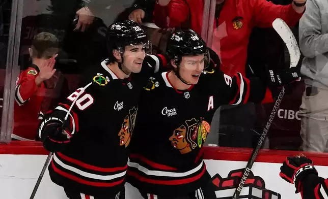 Chicago Blackhawks center Connor Bedard, right, celebrates his goal against the Anaheim Ducks with center Ryan Greene (20) during the third period of an NHL hockey game, Sunday, Nov. 30, 2025, in Chicago. (AP Photo/David Banks)