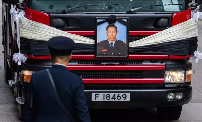 A picture of Ho Wai-ho, the firefighter who lost his life in the line of duty during the deadly fire at Wang Fuk Court on Nov. 26, is displayed on a hearse at a funeral parlor, in Hong Kong, Friday, Dec. 19, 2025. (AP Photo/Chan Long Hei)