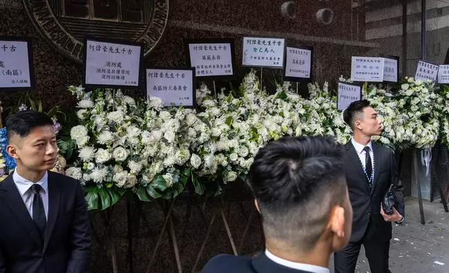 A display of wreaths stand outside a funeral parlor at a tribute to Ho Wai-ho, the firefighter who lost his life in the line of duty during the deadly fire at Wang Fuk Court on Nov. 26, in Hong Kong, Friday, Dec. 19, 2025. (AP Photo/Chan Long Hei)