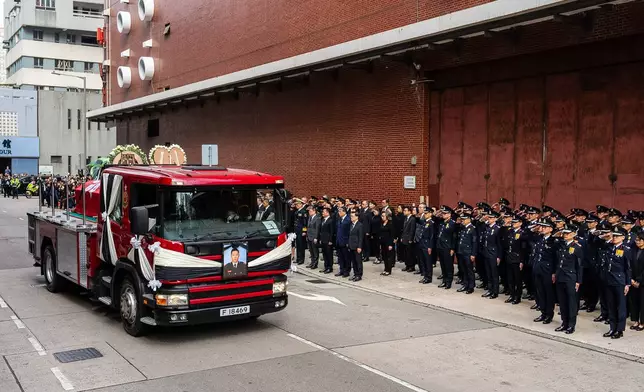 A hearse carries Ho Wai-ho, the firefighter who lost his life in the line of duty during the deadly fire at Wang Fuk Court on Nov. 26, passes by a funeral parlor in Hong Kong, Friday, Dec. 19, 2025. (AP Photo/Chan Long Hei)