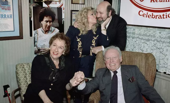 FILE - Sally Struthers plants a kiss on the cheek of Rob Reiner, right, Carroll O'Connor and Jean Stapleton hold hands during a reunion of the cast of "All in the Family," at O'Conner restaurant, Feb. 12, 1991, in Beverly Hill, Calif. (AP Photo/Chris Martinez, File)