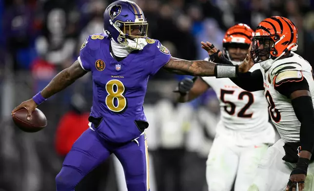Baltimore Ravens quarterback Lamar Jackson (8) is pressured by Cincinnati Bengals defensive end Joseph Ossai (58) during the second half of an NFL football game, Thursday, Nov. 27, 2025, in Baltimore. (AP Photo/Nick Wass)