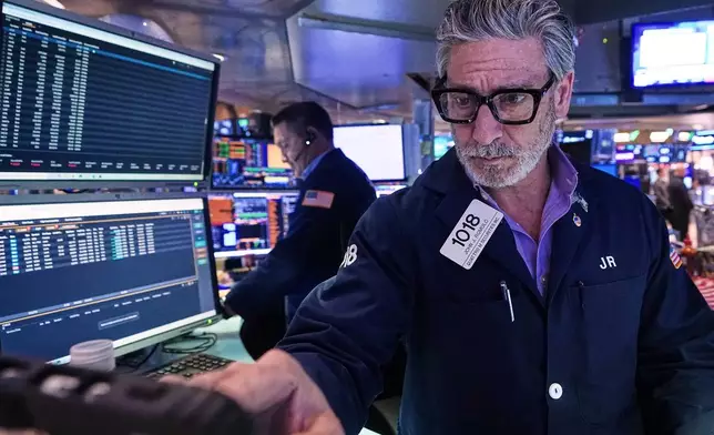 Trader John Romolo works on the floor of the New York Stock Exchange, Tuesday, Dec. 2, 2025. (AP Photo/Richard Drew)