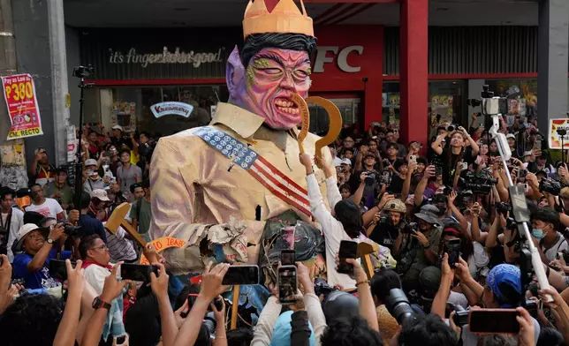 Protesters destroy an effigy of Philippine President Ferdinand Marcos Jr. during an anti-corruption rally in Manila, Philippines on, Sunday, Nov. 30, 2025. (AP Photo/Aaron Favila)