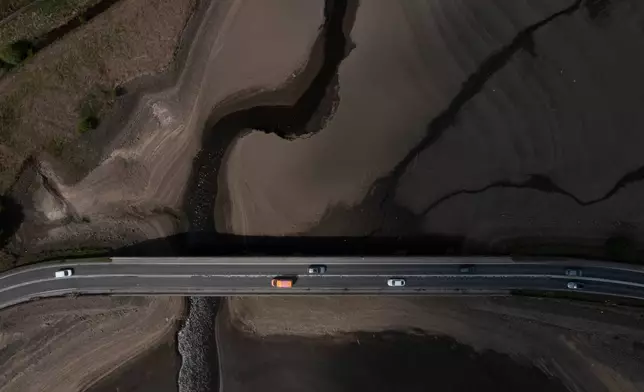 FILE - Traffic crosses a bridge at Woodhead Reservoir in Derbyshire as England experiences a drought in Woodhead, England, May 19, 2025. (AP Photo/Jon Super, File)