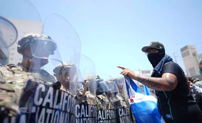 FILE - A protester confronts a line of U.S. National Guard members in the metropolitan detention center of downtown Los Angeles, Sunday, June 8, 2025. (AP Photo/Eric Thayer, File)