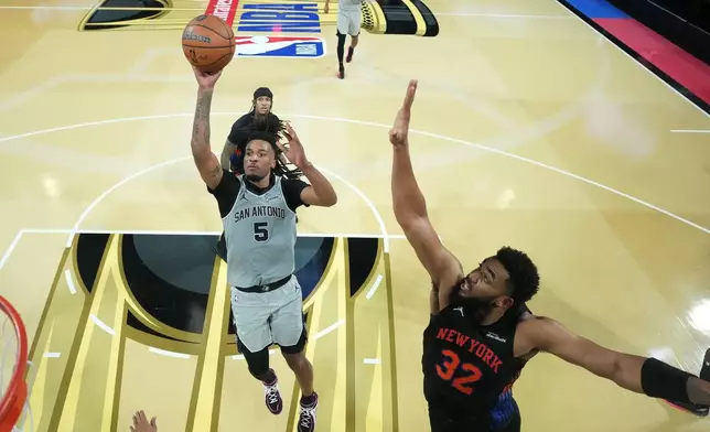 San Antonio Spurs guard Stephon Castle (5) shoots the ball past New York Knicks center Karl-Anthony Towns (32) in the second half of an NBA Cup championship basketball game, Tuesday, Dec. 16, 2025, in Las Vegas. (Kirby Lee/Pool Photo via AP)