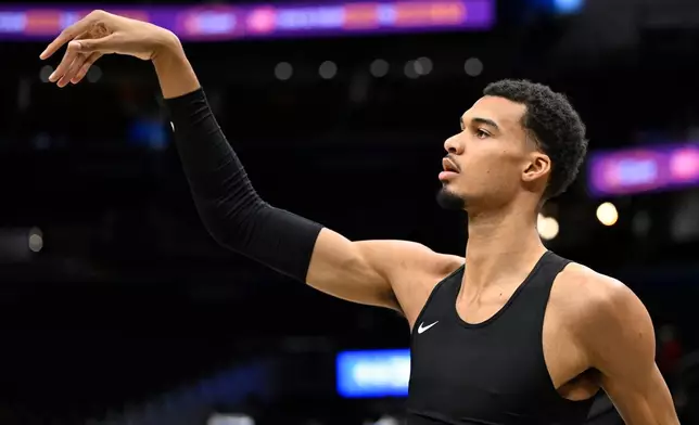 San Antonio Spurs forward Victor Wembanyama warms up before an NBA basketball game against the Washington Wizards, Sunday, Dec. 21, 2025, in Washington. (AP Photo/John McDonnell)