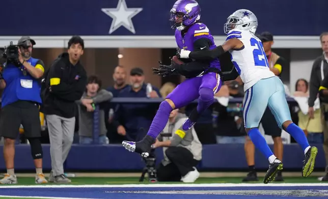 Minnesota Vikings wide receiver Jalen Nailor makes a catch in the end zone for a touchdown as Dallas Cowboys cornerback Daron Bland defends during the first half of an NFL football game Sunday, Dec. 14, 2025, in Arlington, Texas. (AP Photo/Julio Cortez)