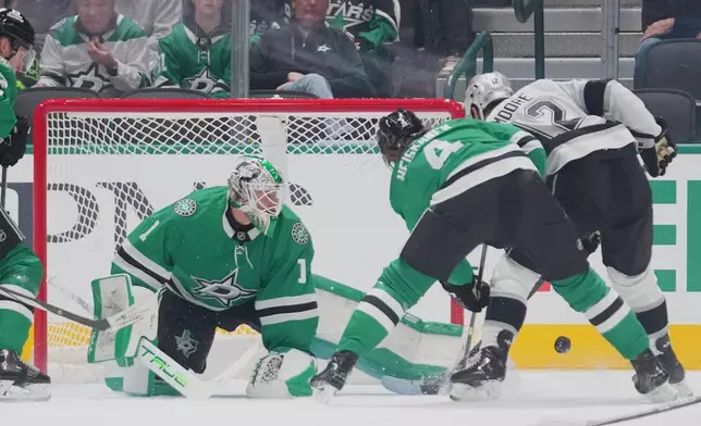 Dallas Stars goaltender Casey Desmith (1) makes a kick save as Los Angeles Kings left wing Trevor Moore (12) attacks during the first period of an NHL hockey game Monday, Dec. 15, 2025, in Dallas. (AP Photo/Julio Cortez)