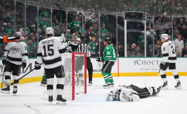 Los Angeles Kings goaltender Darcy Kuemper, bottom right, lies on the ice after a collision with Dallas Stars right wing Mikko Rantanen during the first period of an NHL hockey game Monday, Dec. 15, 2025, in Dallas. (AP Photo/Julio Cortez)
