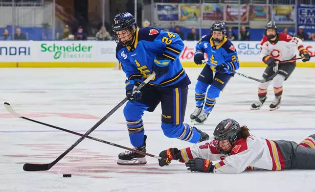 Ottawa Charge's Jocelyne Larocque (3) dives for the puck as she defends against Toronto Sceptres' Natalie Spooner (24) during second period PWHL hockey action in Toronto, Tuesday, Dec. 23, 2025. (Sammy Kogan/The Canadian Press via AP)