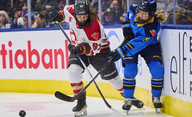 Ottawa Charge's Anna Shokhina (97) and Toronto Sceptres' Daryl Watts (9) battle for the puck during second period PWHL hockey action in Toronto, Tuesday, Dec. 23, 2025. (Sammy Kogan/The Canadian Press via AP)