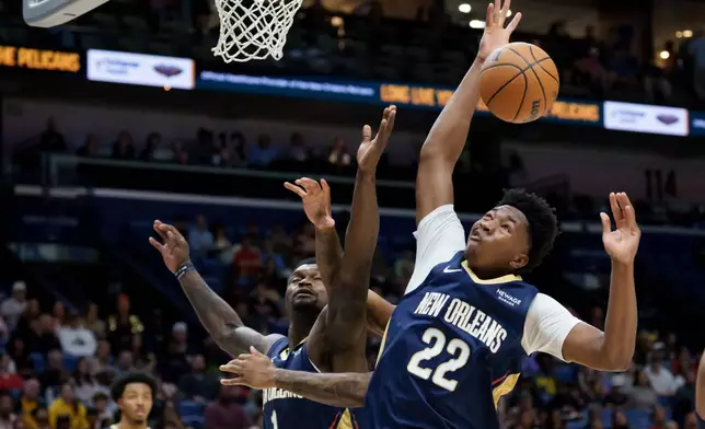 New Orleans Pelicans center Derik Queen (22) and forward Zion Williamson (1) go up for a rebound against the Indiana Pacers during the first half of an NBA basketball game in New Orleans, Saturday, Dec. 20, 2025. (AP Photo/Matthew Hinton)