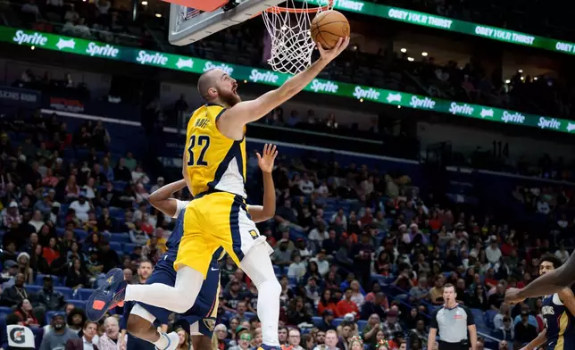 Indiana Pacers center Jay Huff (32) heads to the basket against New Orleans Pelicans center Derik Queen, back left, during the first half of an NBA basketball game in New Orleans, Saturday, Dec. 20, 2025. (AP Photo/Matthew Hinton)