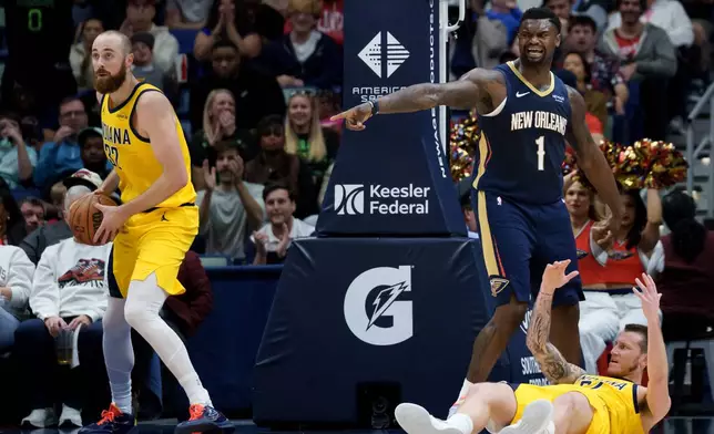 New Orleans Pelicans forward Zion Williamson (1) asks for a foul after dunking against Indiana Pacers center Jay Huff, left, and guard Taelon Peter, bottom right, during the first half of an NBA basketball game in New Orleans, Saturday, Dec. 20, 2025. (AP Photo/Matthew Hinton)