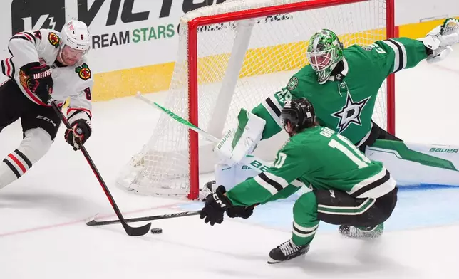 Dallas Stars goaltender Jake Oettinger (29) and center Oskar Back (10) defend the goal against Chicago Blackhawks center Ryan Donato (8) during the second period of an NHL hockey game Saturday, Dec. 27, 2025, in Dallas. (AP Photo/LM Otero)