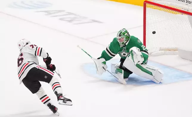 Chicago Blackhawks left wing Nick Lardis (76) scores a goal against Dallas Stars goaltender Jake Oettinger (29) during a shootout after regulation play of an NHL hockey game Saturday, Dec. 27, 2025, in Dallas. (AP Photo/LM Otero)