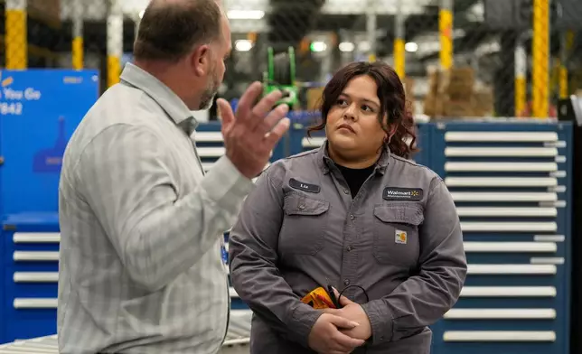 Walmart maintenance technician Liz Cardenas talks to R.J. Zanes, vice president of facility services, at a training area in a Walmart distribution center Thursday, Sept. 25, 2025, in Bentonville, Ark. (AP Photo/Charlie Riedel)