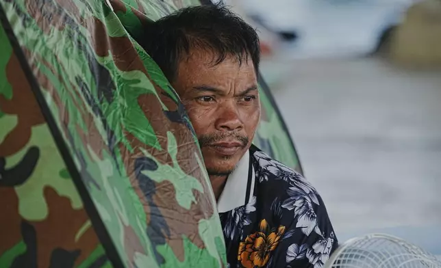 A man sits in a tent as he takes refuge in Banteay Menchey provincial town, Cambodia, Saturday, Dec. 13, 2025, after fleeing home following fighting between Thailand and Cambodia. (AP Photo/Heng Sinith)