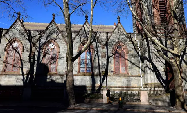 A Brown University student walks past a church on the Providence, RI, campus, Thursday, Dec. 18, 2025. (AP Photo/ Mark Stockwell)