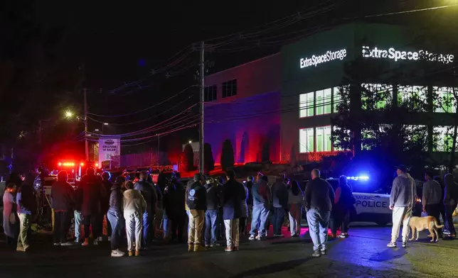 People gather outside a storage facility where a suspect in the shooting at Brown University was found dead, Thursday, Dec. 18, 2025, in Salem, N.H. (AP Photo/Reba Saldanha)