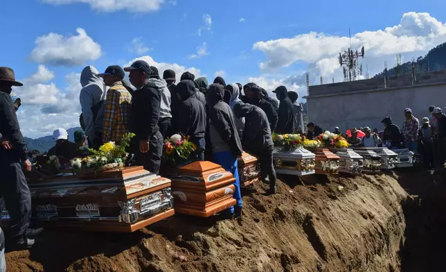 People bury victims in a mass grave following an attack by armed men on a military post and a police station in Nahuala, Guatemala, Sunday, Dec. 14, 2025. (AP Photo/Mariano Rosales)