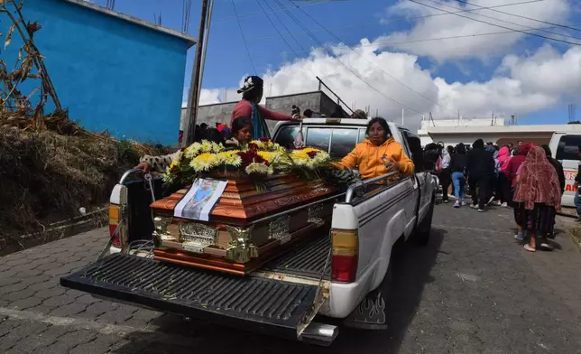People transport a coffin following an attack by armed men on a military post and a police station in Nahuala, Guatemala, Sunday, Dec. 14, 2025. (AP Photo/Mariano Rosales)