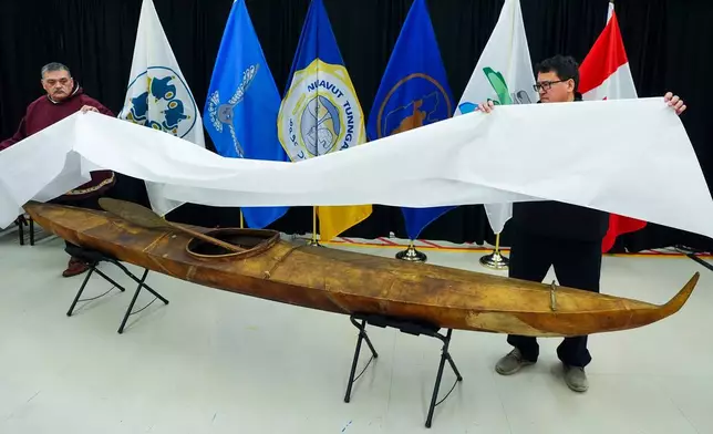 Darrel Nasogaluak, Elder and Chair of Tuktoyaktuk Community Corp., left, and Duane Smith, Chair and CEO of the Inuvialuit Regional Corp., unveil a traditionally built Inuvialuit kayak at the Canadian Museum of History in Gatineau, Que., on Tuesday, Dec. 9, 2025. (Sean Kilpatrick /The Canadian Press via AP)