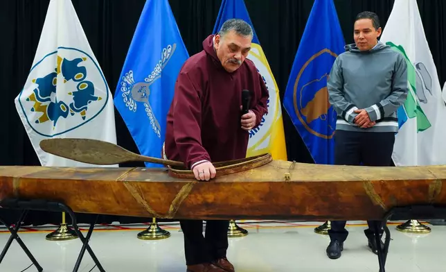 Darrel Nasogaluak, Elder and Chair of Tuktoyaktuk Community Corp., middle, answers questions with Natan Obed, President of Inuit Tapiriit Kanatami, as a selection of Inuit items, including a traditionally built Inuvialuit kayak, are unveiled at the Canadian Museum of History in Gatineau, Que., on Tuesday, Dec. 9, 2025. (Sean Kilpatrick /The Canadian Press via AP)