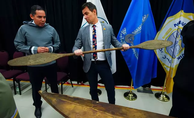 Natan Obed, President of Inuit Tapiriit Kanatami, left, stands with Adam van Koeverden, Secretary of State (Sport) and gold medal Olympic kayaker, as a selection of Inuit items, including a traditionally built Inuvialuit kayak and paddle, are unveiled at the Canadian Museum of History in Gatineau, Que., on Tuesday, Dec. 9, 2025. (Sean Kilpatrick /The Canadian Press via AP)
