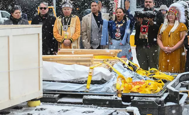 Assembly of First Nations National Chief Cindy Woodhouse Nepinak, right, along with representatives from various First Nations receive a kayak and other indigenous artifacts at Trudeau Airport in Montreal, Saturday, Dec. 6, 2025, after they were returned by the Vatican. (Graham Hughes /The Canadian Press via AP)