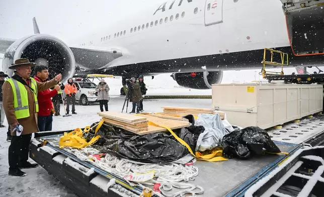 Representatives from various First Nations look on as a kayak and other indigenous artifacts arrive at Trudeau Airport in Montreal, Saturday, Dec. 6, 2025, after they were returned by the Vatican. (Graham Hughes /The Canadian Press via AP)