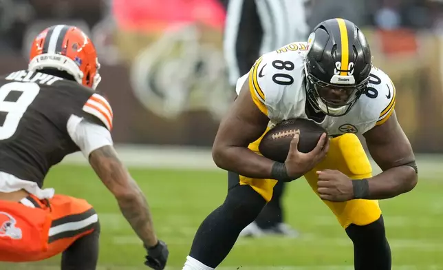 Pittsburgh Steelers tight end Darnell Washington (80) catches a pass in front of Cleveland Browns safety Grant Delpit (9) during the first half of an NFL football game, Sunday, Dec. 28, 2025, in Cleveland. (AP Photo/Sue Ogrocki)
