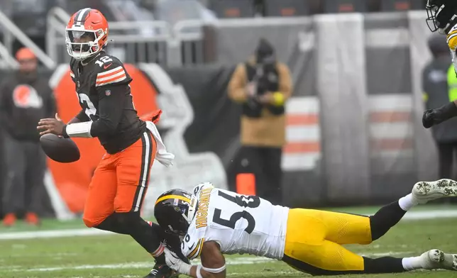 Cleveland Browns quarterback Shedeur Sanders (12) tries to break a tackle by Pittsburgh Steelers linebacker Alex Highsmith (56) during the second half of an NFL football game, Sunday, Dec. 28, 2025, in Cleveland. (AP Photo/David Richard)