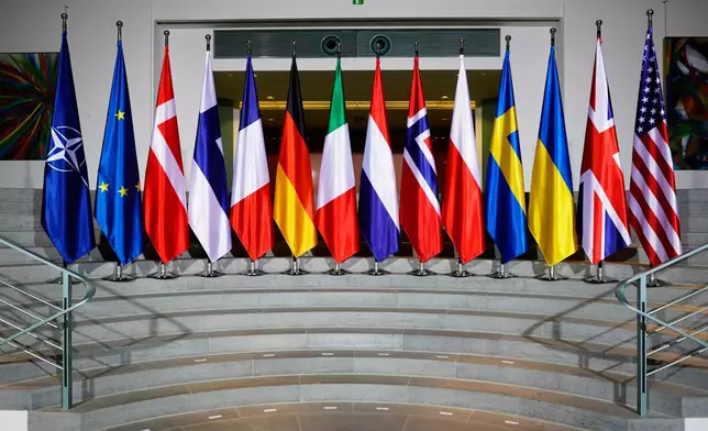 The flags of the participating nations are seen at the chancellery in Berlin, Germany, Monday, Dec. 15, 2025. (AP Photo/Markus Schreiber,Pool)