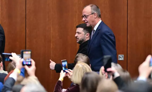 Ukraine's President Volodymyr Zelenskyy, center left, and German Chancellor Friedrich Merz, center right, attend the German-Ukrainian Economic Forum in Berlin, Germany, Monday, Dec. 15, 2025. (Sebastian Christoph Gollnow/dpa via AP)