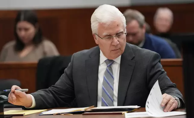 Michigan football coach Sherrone Moore's attorney Joseph A. Simon looks over papers in court on Friday, Dec. 12, 2025 in Ann Arbor, Mich. (AP Photo/Ryan Sun, Pool)
