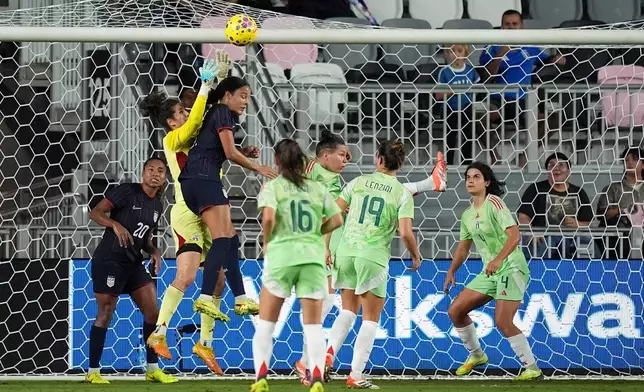Italy goalkeeper Francesca Durante (22) jumps to deflect a shot against United States defender Jordyn Bugg (2) during the first half of an international friendly soccer match, Monday, Dec. 1, 2025, in Fort Lauderdale, Fla. (AP Photo/Rebecca Blackwell)
