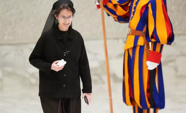 Sister Raffaella Petrini, left, President of the Vatican City State walks at the end of an audience with Pope Leo XIV with donors of the Christmas tree and nativity scene set up in St. Peter's Square, in the Paul VI Hall, at the Vatican, Monday, Dec. 15, 2025. (AP Photo/Alessandra Tarantino)