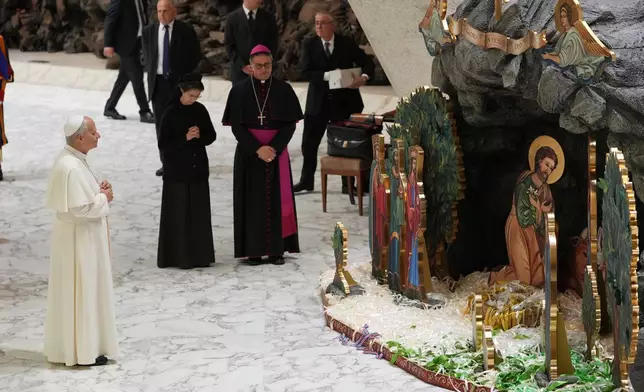 Pope Leo XIV prays in front of Nacimiento Gaudium, a nativity scene set in the Paul VI Hall adorned with 28,000 ribbons representing lives saved from abortion according to Catholic organizations, during an audience with donors of the Christmas tree and of the nativity scenes, at the Vatican Monday, Dec. 15, 2025. (AP Photo/Alessandra Tarantino)